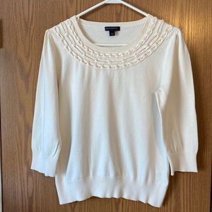 3 quarter length sweater that sits at the waist, chain detail at neckline